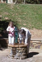 Hepburn Springs, Tara and Alex demonstrating the use of one of the pumps; daylesford_spring3.jpg - 17056 Bytes